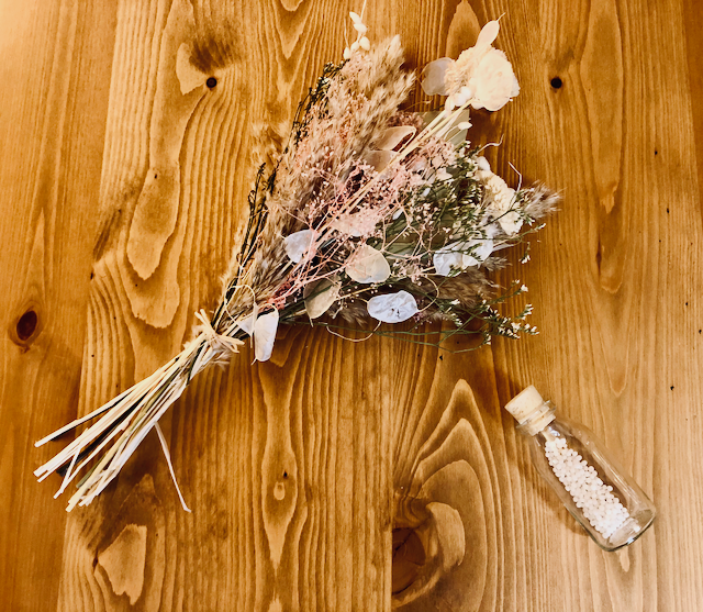 Remède homéopathique et bouquet de fleurs séchées sur une table en bois